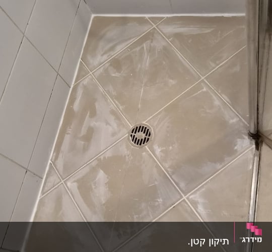 מקלחת עם אריחים ורצפה מלוכלכת